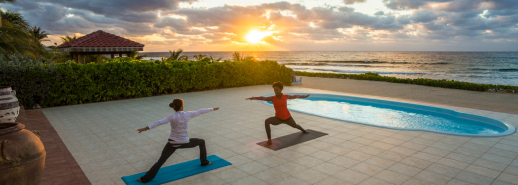 women doing yoga by a pool at the Le Soleil d’Or, Cayman Islands